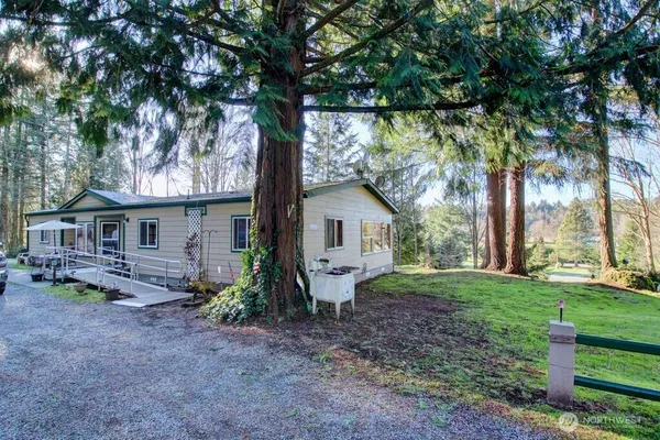 a view of a house with backyard and a tree