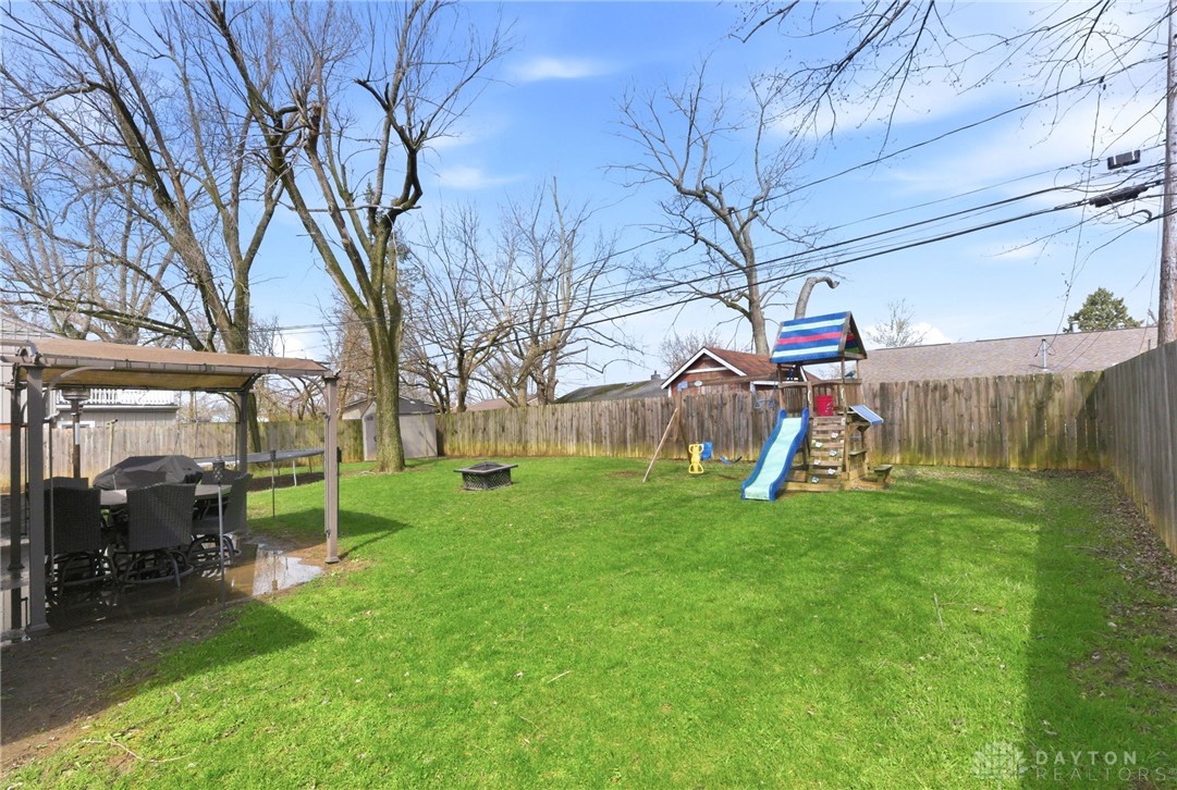 5171 Fishburg Road Dayton, OH 45424 - Photo 30 of 35 This spacious yard features a covered patio perfect for outdoor gatherings and a playset for recreation.