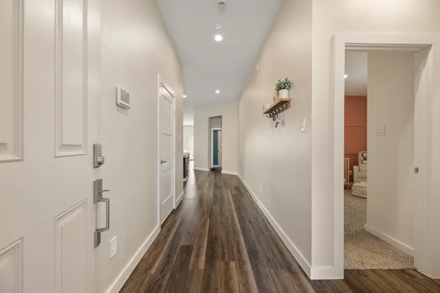 a view of a hallway with wooden floor and staircase