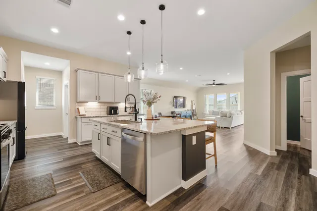 a kitchen with kitchen island a stove a sink and a refrigerator