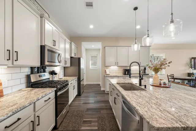 a kitchen with stainless steel appliances granite countertop a sink stove and refrigerator