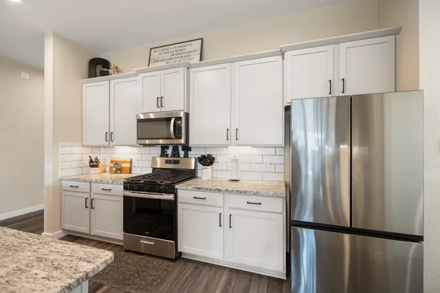 a kitchen with stainless steel appliances a refrigerator sink and cabinets