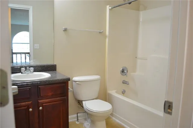 a bathroom with a granite countertop toilet a sink and a bathtub