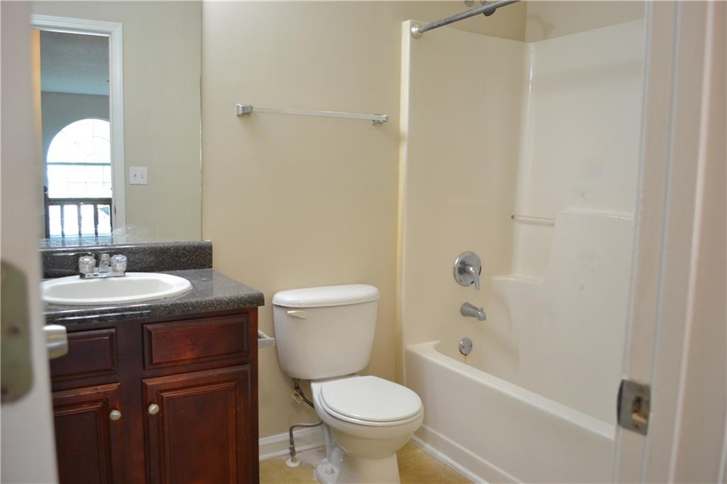 6157 Red Top Loop Union City, GA 30291 - Photo 25 of 26 a bathroom with a granite countertop toilet a sink and a bathtub