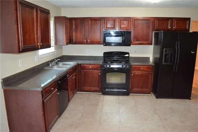 a kitchen with stainless steel appliances granite countertop a refrigerator stove a sink and dishwasher