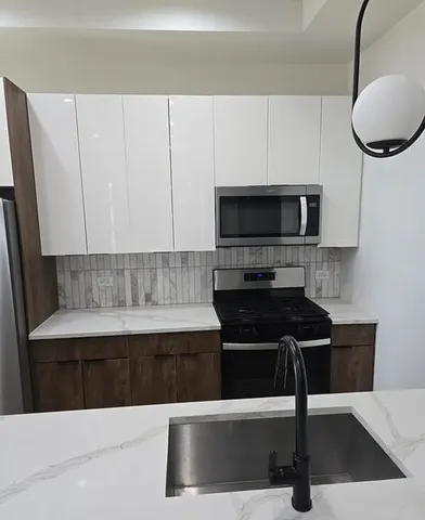 a kitchen with a sink and a stove top oven