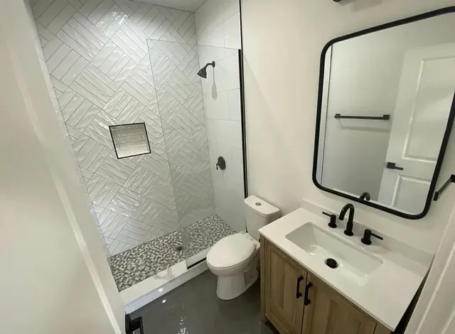 a bathroom with a sink mirror toilet and shower