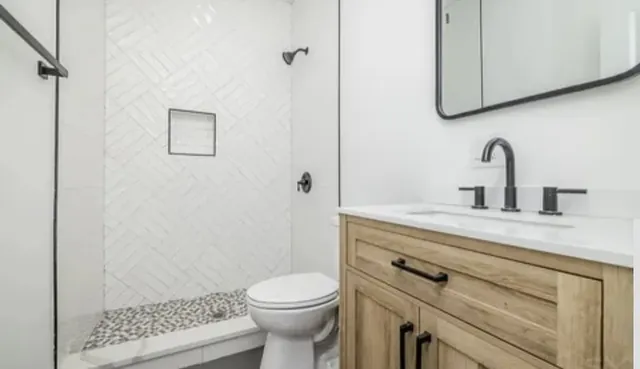 a bathroom with a sink a toilet and shower