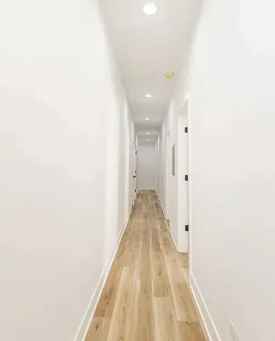a view of a hallway with wooden floor