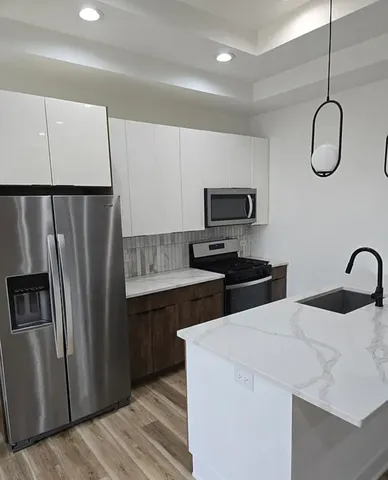 a kitchen with stainless steel appliances a refrigerator sink and microwave