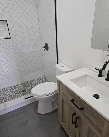 a bathroom with a sink a toilet and shower