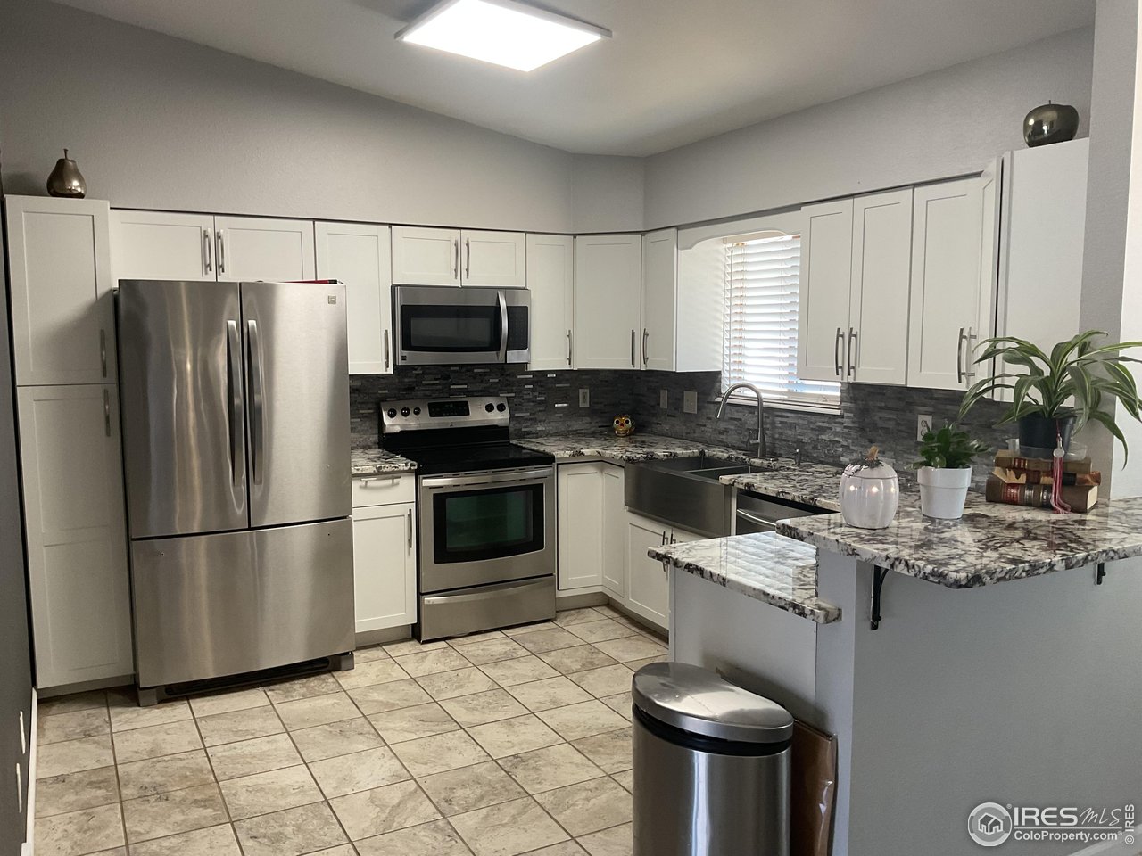 402 Gayle Street Fort Morgan, CO 80701 - Photo 6 of 40 a kitchen with stainless steel appliances granite countertop a refrigerator sink stove microwave and cabinets