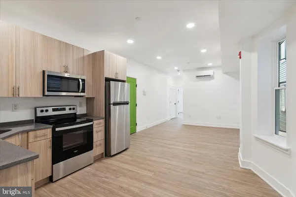a kitchen with stainless steel appliances kitchen island granite countertop a stove a refrigerator and a microwave