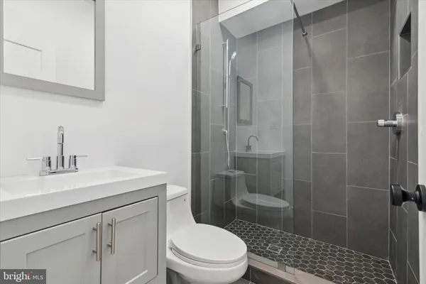 a bathroom with a sink a toilet and shower