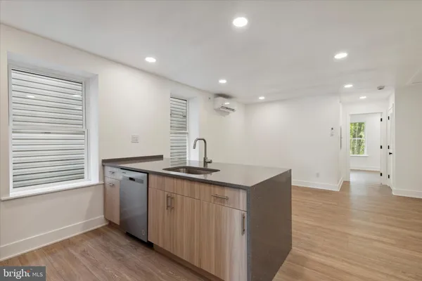 a kitchen with stainless steel appliances granite countertop a sink a stove and a wooden floors