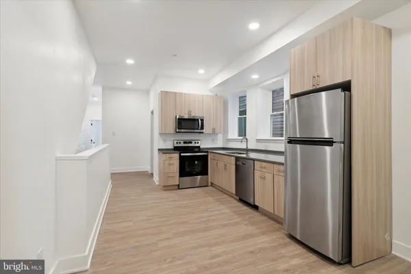 a kitchen with refrigerator a sink and white cabinets