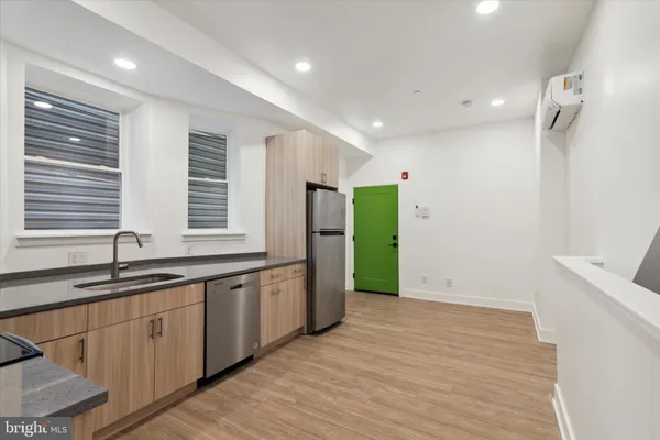 a kitchen with stainless steel appliances granite countertop a sink and a refrigerator