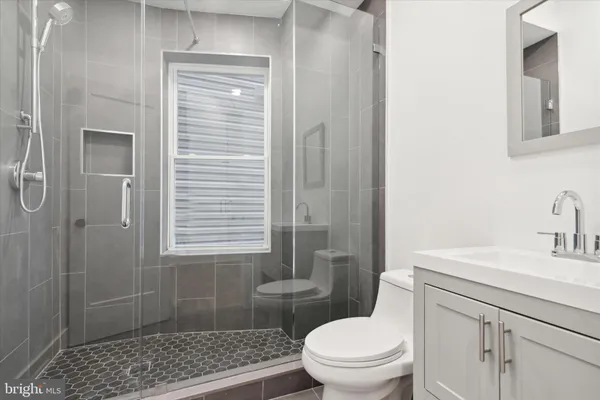 a bathroom with a sink a toilet and shower