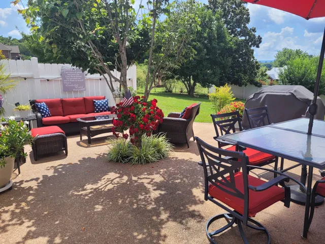 a view of a garden with a tree in front of the house