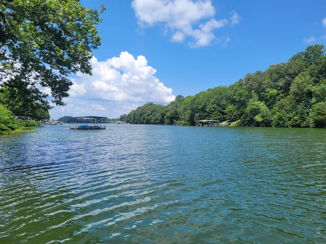 an outdoor sitting area with furniture and lake view