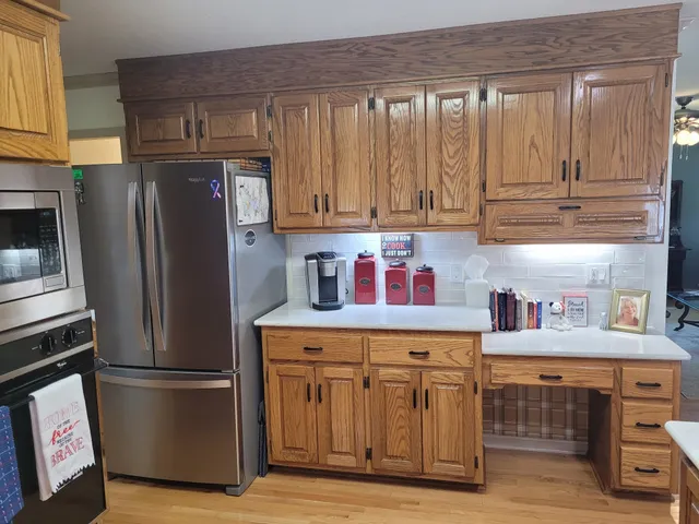 a kitchen with stainless steel appliances granite countertop a refrigerator and a stove top oven