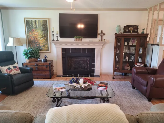 a living room with furniture a flat screen tv and a fireplace