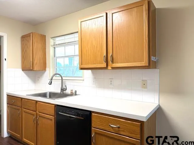 a kitchen with stainless steel appliances a sink a cabinets and next to a window