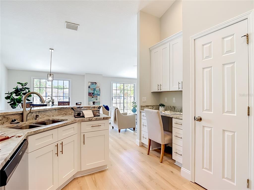 5310 Anhinga Trail New Port Richey, FL 34653 - Photo 9 of 27 a kitchen with white cabinets and wooden floor