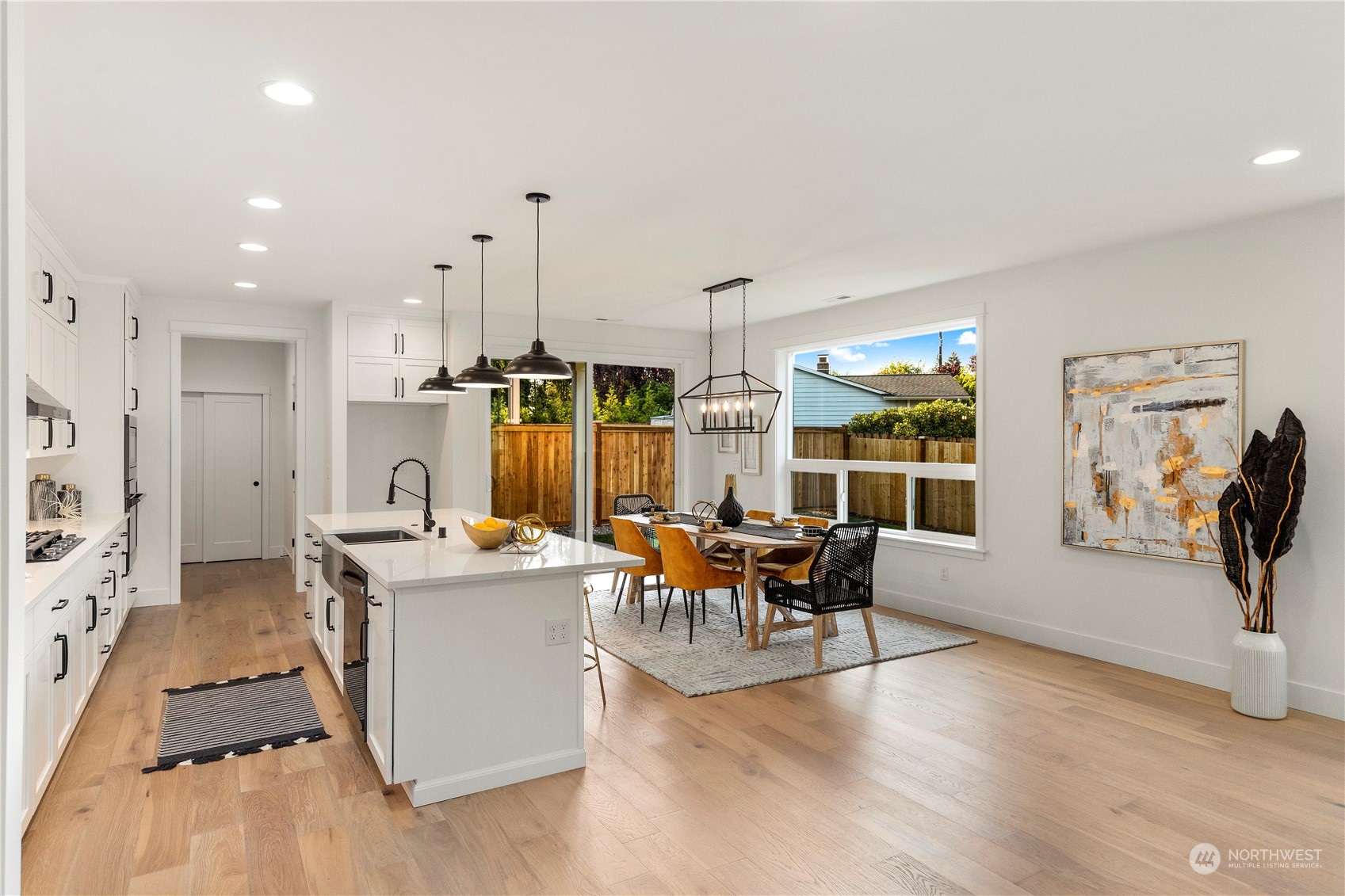 7 179th Place Southwest Bothell, WA 98012 - Photo 9 of 33 a kitchen with stainless steel appliances dining table chairs and wooden floor
