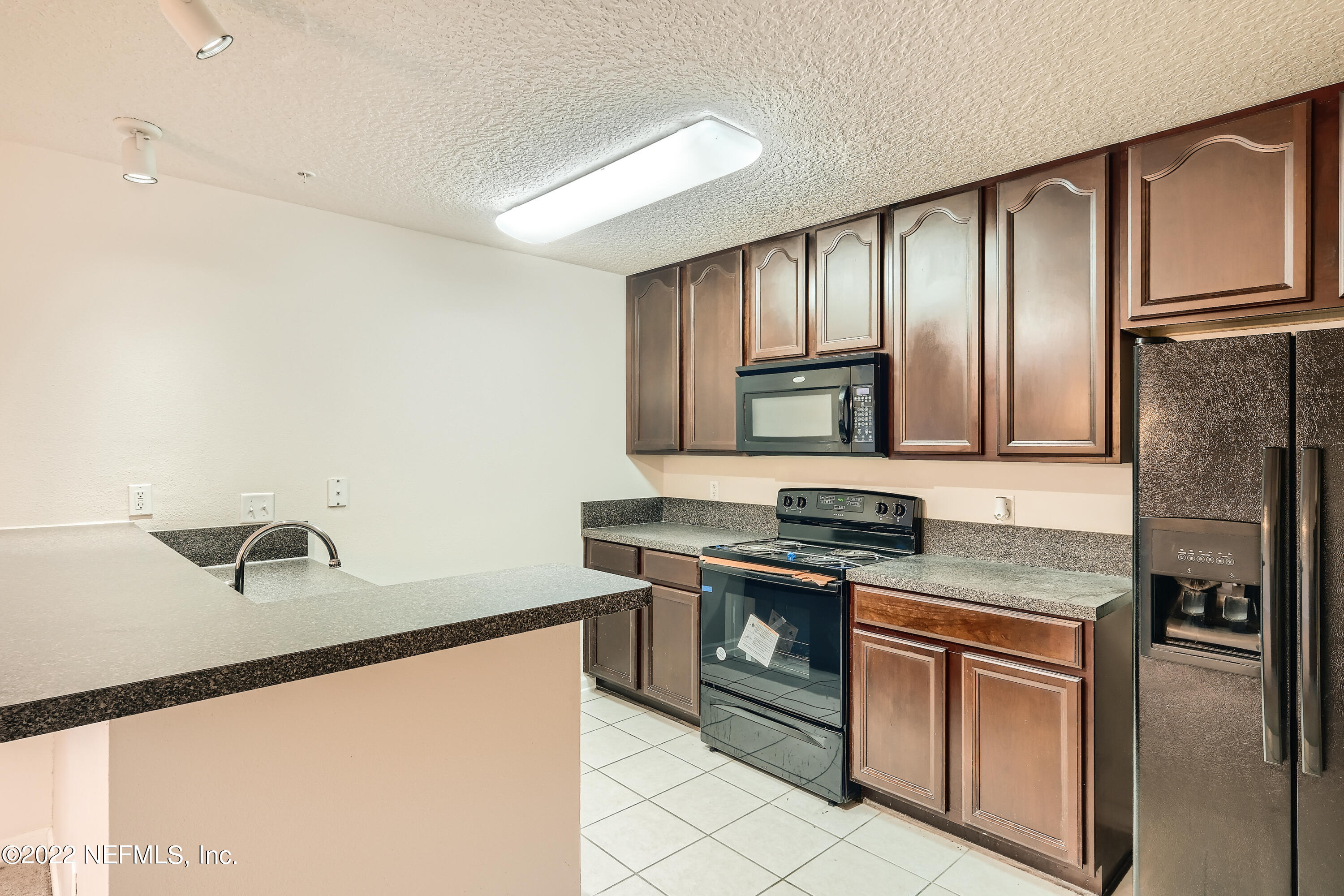 511 Golden Lake Loop St. Augustine, FL 32084 - Photo 11 of 32 a kitchen with stainless steel appliances granite countertop a stove a sink and a refrigerator with wooden cabinets