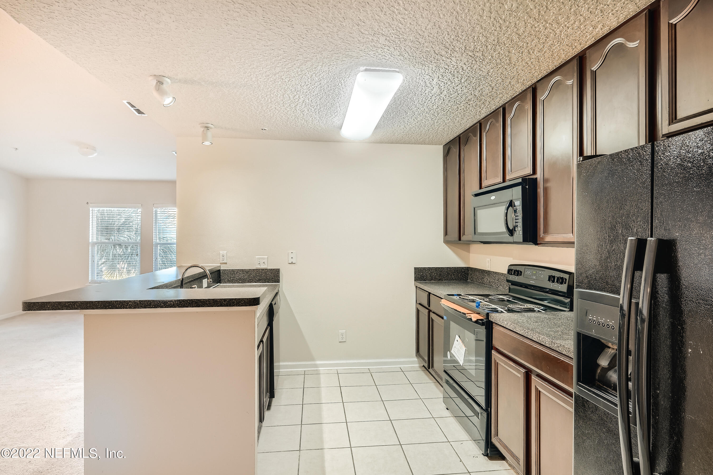 511 Golden Lake Loop St. Augustine, FL 32084 - Photo 12 of 32 a kitchen with granite countertop a sink stove and refrigerator