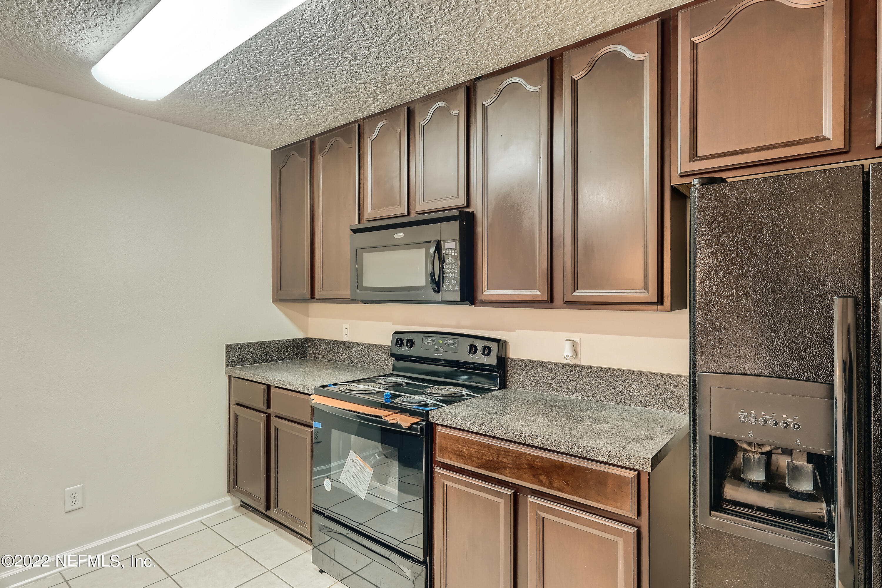 511 Golden Lake Loop St. Augustine, FL 32084 - Photo 13 of 32 a kitchen with stainless steel appliances granite countertop a sink and a refrigerator