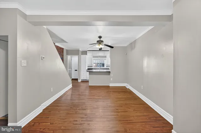 a view of a kitchen with wooden floor electronic appliances and a window