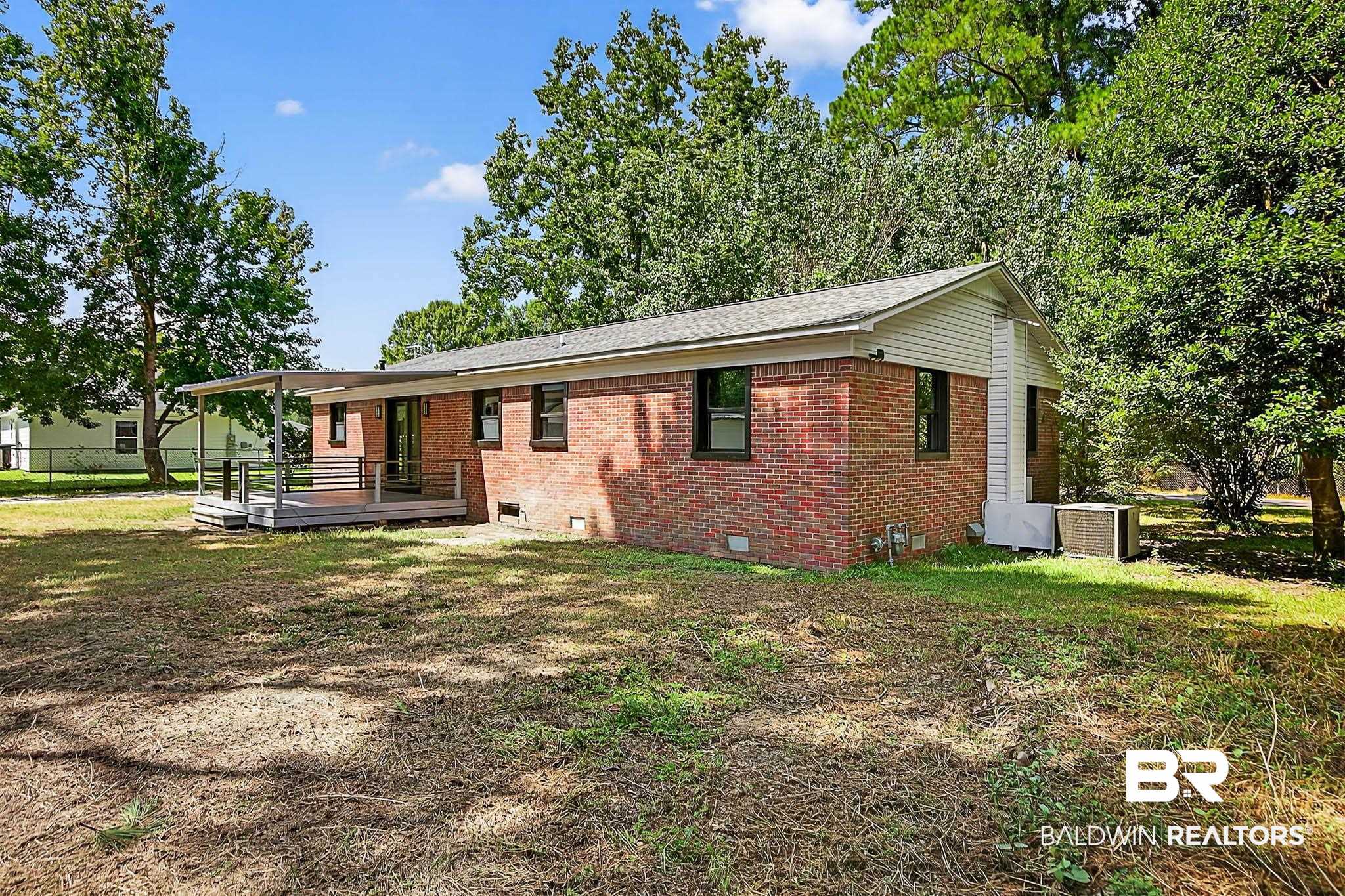 101 Terry Avenue Brewton, AL 36426 - Photo 6 of 48 View of front facade featuring crawl space, a wooden deck, brick siding, and a front yard