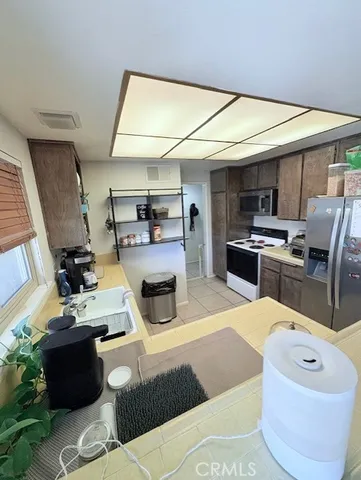 a living room with furniture a flat screen tv and kitchen view