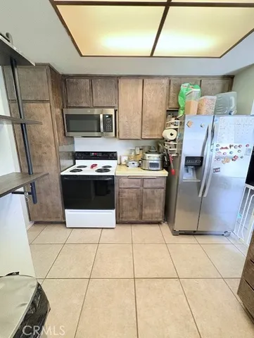 a kitchen with granite countertop a stove a sink dishwasher and a refrigerator