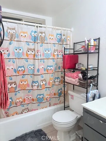 a room with stainless steel appliances a rug and a couch