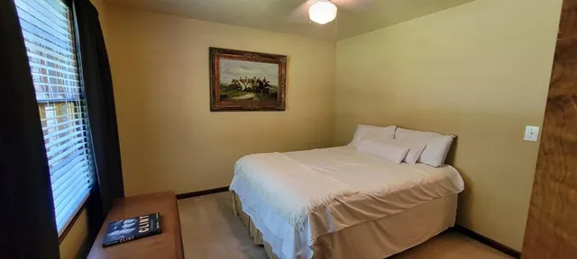 a bedroom with a bed and a painting on the wall