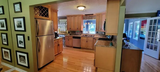 a kitchen with stainless steel appliances granite countertop a refrigerator a stove a sink and a refrigerator