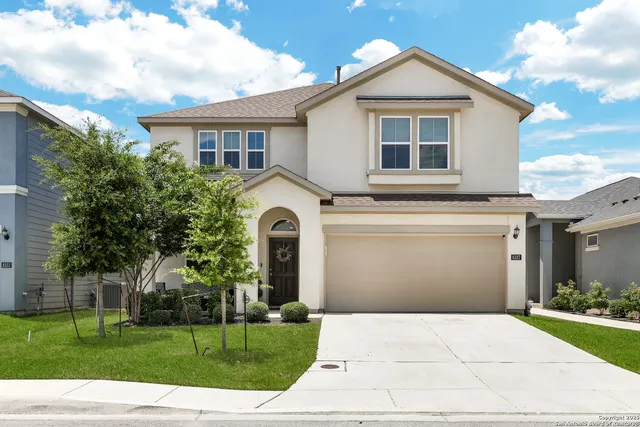 a front view of a house with a yard and garage