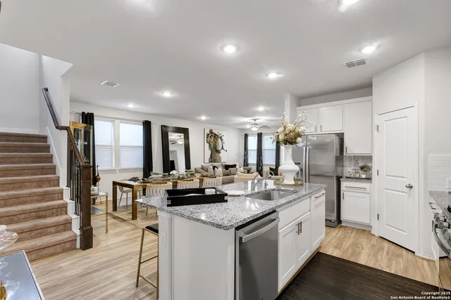 a kitchen with stainless steel appliances granite countertop a refrigerator a stove and a sink