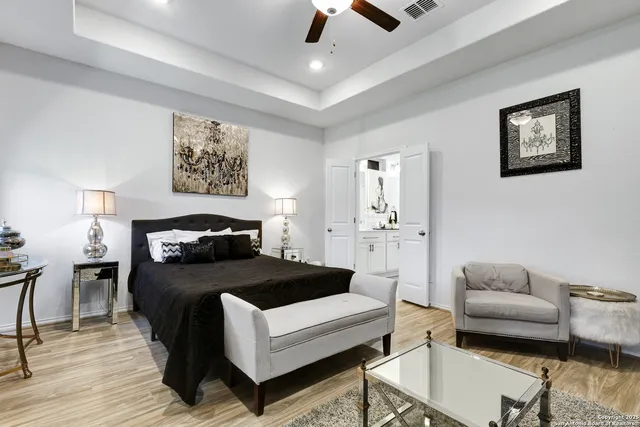 a bedroom with a bed a couch and painting on the wall