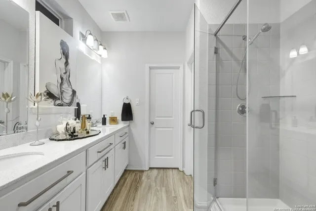 a spacious bathroom with a double vanity sink mirror and shower