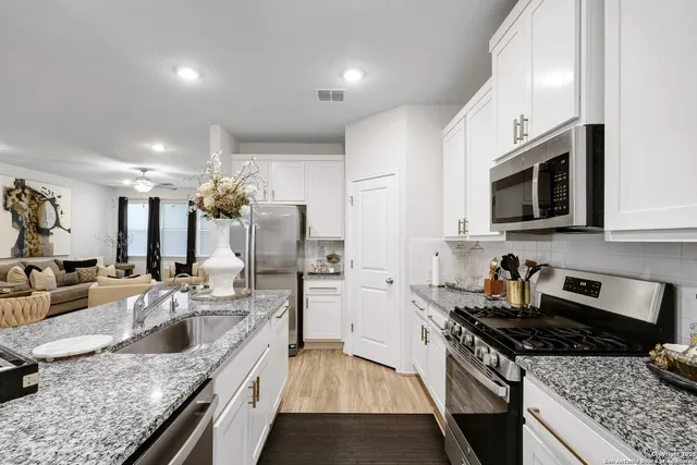a kitchen with stainless steel appliances granite countertop a sink stove and refrigerator