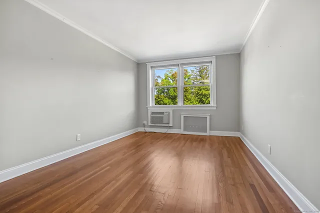 a roof deck with couple of chairs and wooden fence