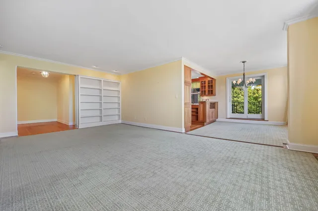 a view of an empty room with a window and fireplace