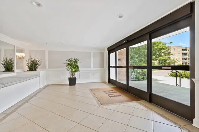 a living room with a large window and a potted plant