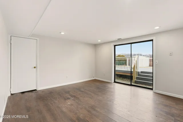 an empty room with wooden floor and sliding door