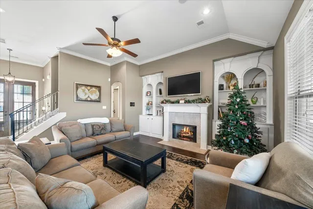 a living room with furniture a fireplace and a flat screen tv