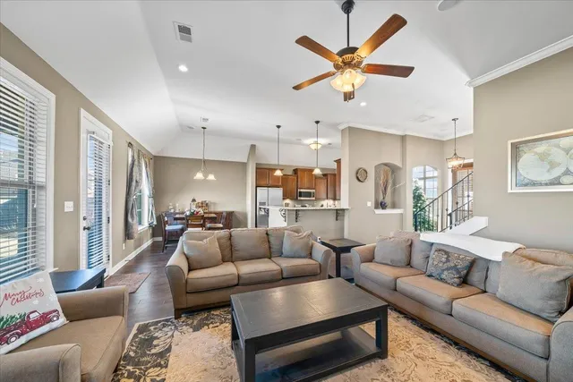 a living room with furniture kitchen view and a chandelier
